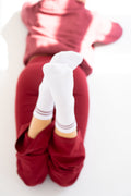 Lavoréa Pilates Cushioned Grip Socks in Burgundy, feet crossed with the grip sole visible