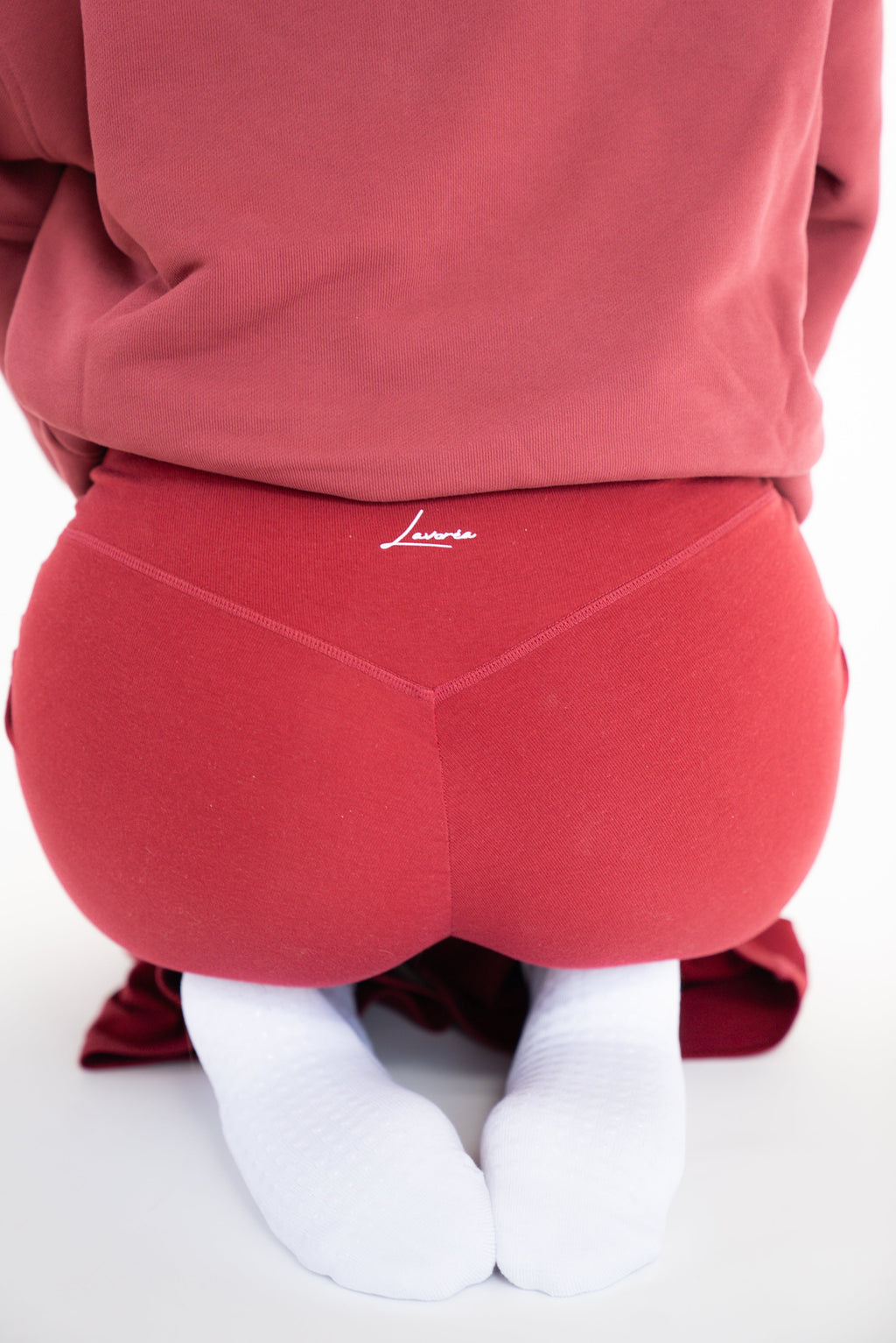 Lavoréa Pilates Cushioned Grip Socks in Burgundy, kneeling with both grip soles in view