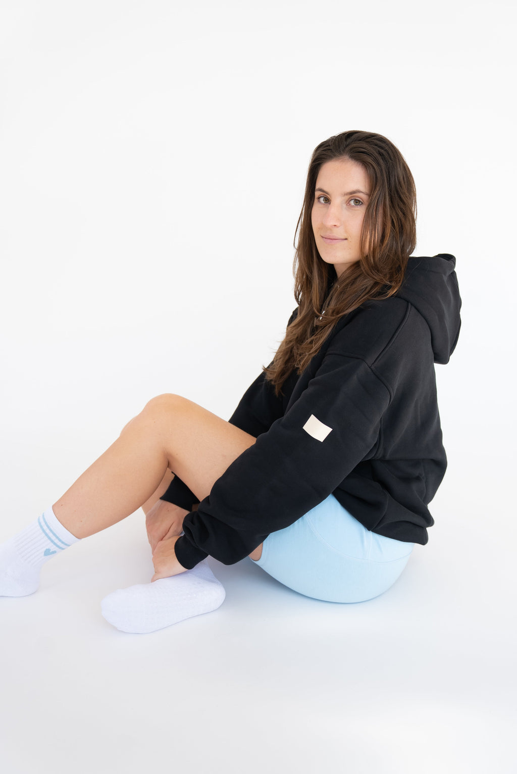 Lavoréa Pilates Grip Socks in Light Blue, seated pose adjusting the sock