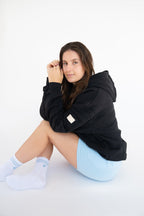 Lavoréa Pilates Grip Socks in Light Blue, seated pose with the grip sole toward the camera